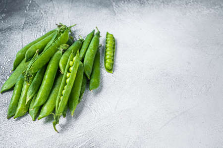 Peas and green pea pods on a kitchen table. White background. Top view. Copy spaceの写真素材