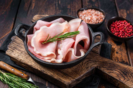 Prosciutto ham sliced in a pan. Dark wooden background. Top viewの写真素材