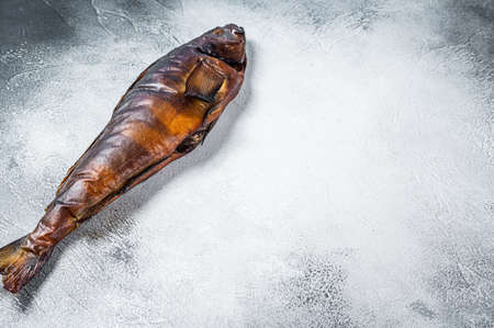 Hot smoked whole fish on kitchen table. White background. Top view. Copy spaceの写真素材
