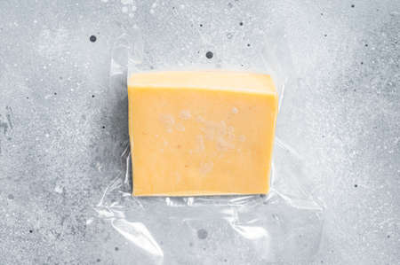 Organic Sharp Cheddar Cheese in vacuum packaging. Gray background. Top viewの写真素材