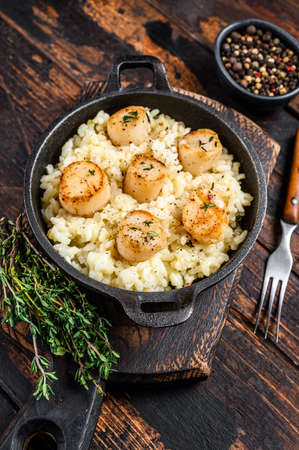 Seafood Risotto with Scallops in a pan. Dark wooden background. Top viewの写真素材