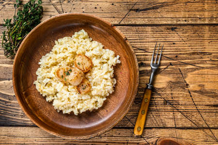 Italian Risotto with Scallops in a pan. wooden background. Top view. Copy spaceの写真素材