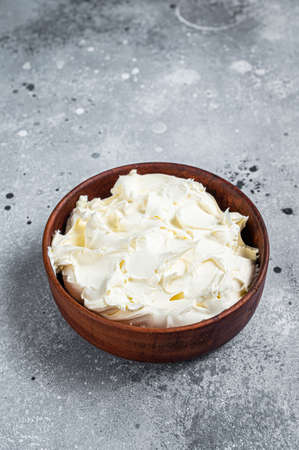 Traditional Mascarpone cheese in wooden bowl. Gray background. Top viewの写真素材