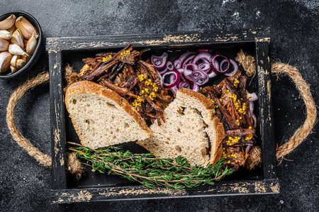 Brisket Sandwich with smoked beef meat in a wooden tray. Black background. Top viewの写真素材