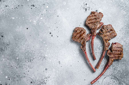 Grilled lamb mutton meat chops steaks. Gray background. Top view. Copy space
