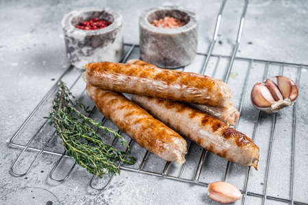 Grilled Bratwurst pork meat sausages on a grill. Gray background. Top viewの写真素材