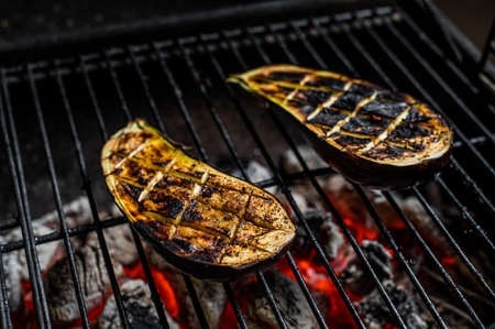 Eggplant on barbecue, outdoor BBQ grill with fire. Top viewの写真素材
