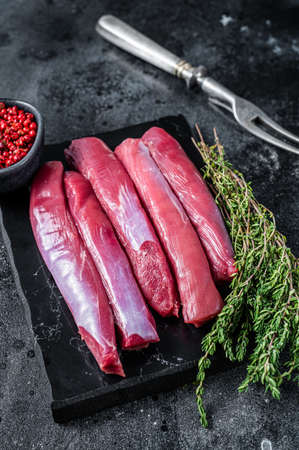 Fresh Raw lamb tenderloin Fillet, Mutton Sirloin Meat on marble board with thyme. Black background. Top viewの写真素材