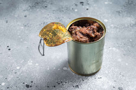 Canned horse meat in metal can. Gray background. Top view. Copy space