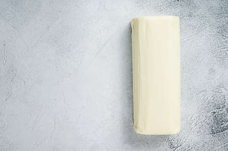 Piece of fresh butter for breakfast on kitchen table. White background. Top view. Copy space