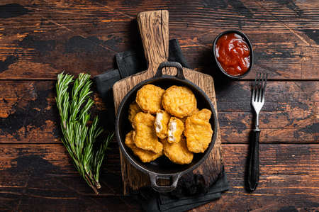 Fastfood - Chicken fried nuggets in a pan. Wooden background. Top viewの写真素材