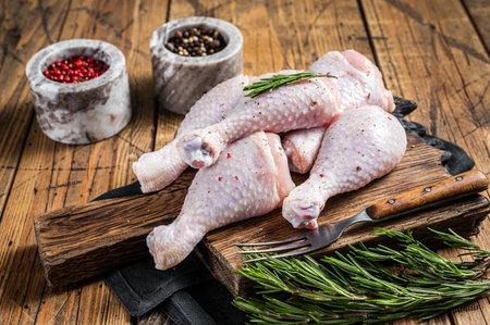 Fresh Chicken drumsticks legs with skin, raw poultry meat. Wooden background. Top viewの写真素材