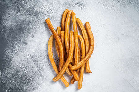 Churros fried sticks on kitchen table. White background. Top view