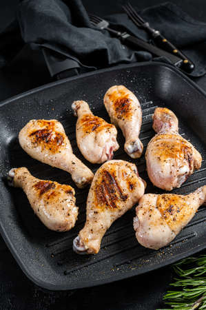 Grilled Chicken leg drumstick with herbs, poultry meat. Black background. Top viewの写真素材