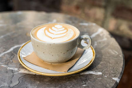 Cappuccino white coffee cup with heart shape art. Marble table. Top viewの写真素材
