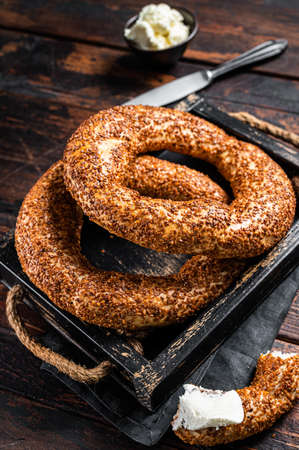 Stack of fresh baked Turkish simit bagel with kaymak. Wooden background. Top view