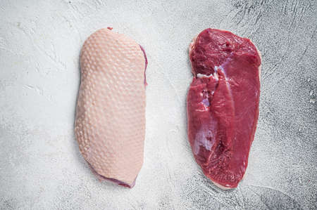 Raw uncooked Duck breast fillet steaks on butcher table. White background. Top Viewの写真素材