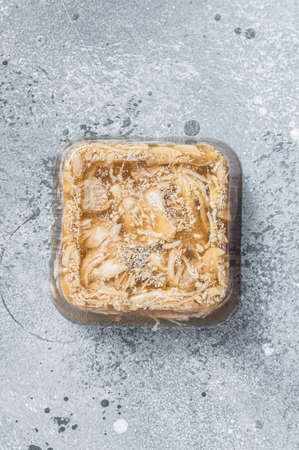 Aspic chicken meat jelly on kitchen table. Gray background. Top view