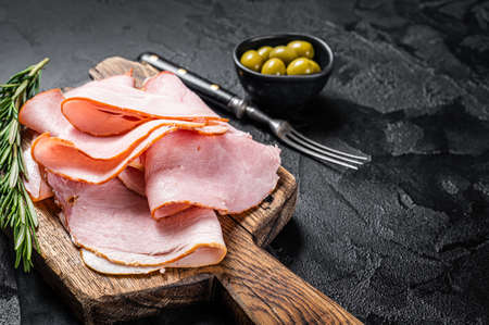 Pork ham slices on cutting board, Italian Prosciutto cotto. Black background. Top view. Copy spaceの写真素材