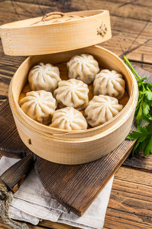 Momo dumplings in a bamboo steamer. Wooden background. Top viewの写真素材