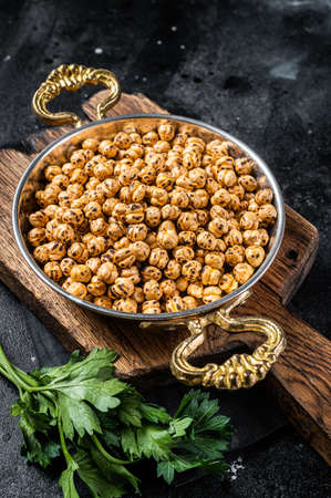 Fried chickpeas with turmeric, roasted spicy chickpeas or Indian chana or chole in a skillet. Black background. Top viewの写真素材