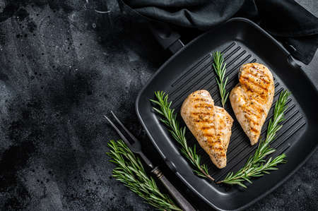 Grilled healthy chicken breasts cooked on a grill pan. Black background. Top view. Copy spaceの写真素材