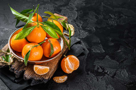 Clementines Tangerines with green leaves. Black background. Top view. Copy spaceの写真素材
