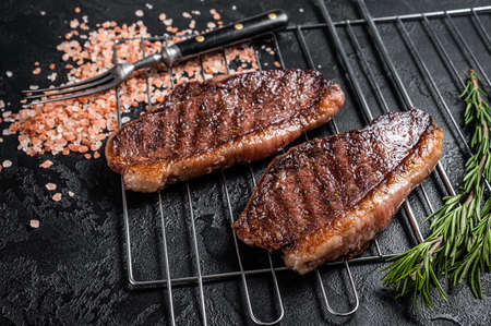 BBQ Grilled cap rump or Top sirloin beef steak, fried meat on grill. Black background. Top viewの写真素材