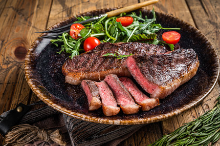 BBQ Grilled cup rump beef meat steak in plate with vegetable salad. Wooden background. Top viewの写真素材