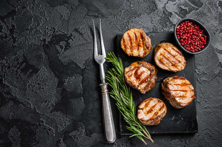 BBQ grilled pork medallions steaks, tenderloin fillet meat. Black background. Top view. Copy spaceの写真素材