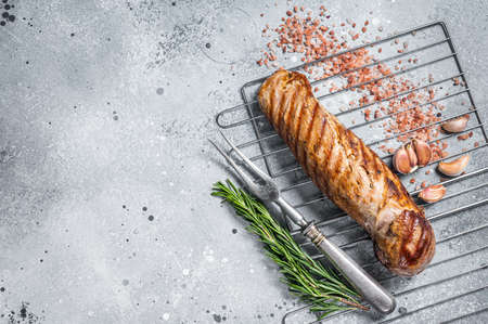 Grilled pork tenderloin fillet meat on grill. Gray background. Top view. Copy spaceの写真素材