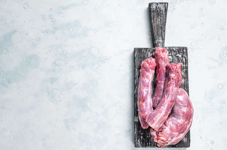 Raw Turkey or chicken necks meat on a wooden board with thyme. White background. Top View. Copy...