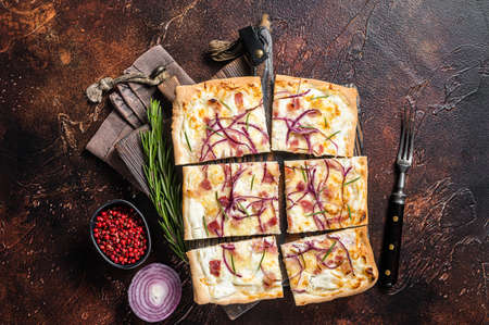 French tarte flambee with cream cheese, bacon and onions. Flammkuchen from Alsace region. Dark...