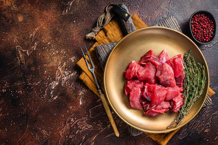 Raw diced lamb mutton meat with thyme. Dark background. Top view. Copy spaceの写真素材