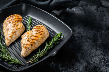Grilled healthy chicken breasts cooked on a grill pan. Black background. Top view. Copy spaceの写真素材