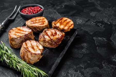 BBQ grilled pork medallions steaks, tenderloin fillet meat. Black background. Top view. Copy spaceの写真素材