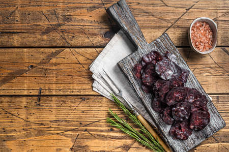 Horse game meat cured sausage with rosemary on a cutting board. Wooden background. Top view. Copy spaceの写真素材