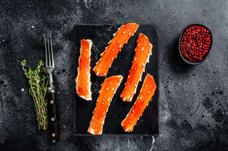 Crab legs Phalanx on a marble board with thyme. Black background. Top viewの写真素材