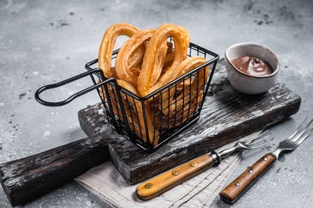 Traditional Spanish dessert churros with sugar and chocolate. Gray background. Top viewの写真素材