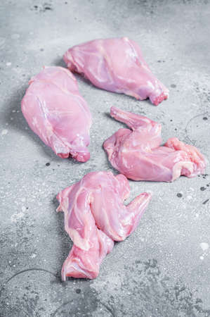 Raw rabbit legs slices on a butcher board. Gray background. Top viewの写真素材