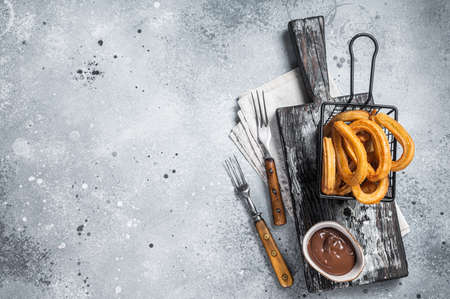 Traditional Spanish dessert churros with sugar and chocolate. Gray background. Top view. Copy spaceの写真素材