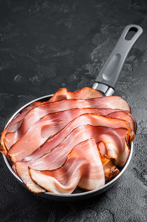 Cooking of Black Forest Ham in skillet. Black background. Top viewの写真素材