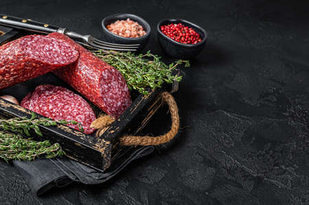 Sliced Dry salami sausage with fresh thyme. Black background. Top view. Copy spaceの写真素材