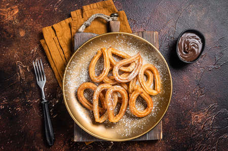 Spanish dessert churros with hot spicy chocolate. Dark background. Top viewの写真素材