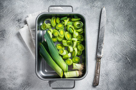 Chopped Green Leek onion with leafs in tray. White background. Top viewの写真素材