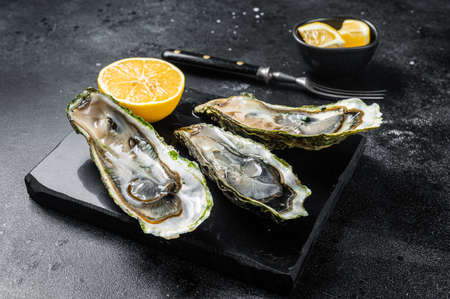 Seafood Brassiere, open Oysters with lemon. Black background. Top viewの写真素材