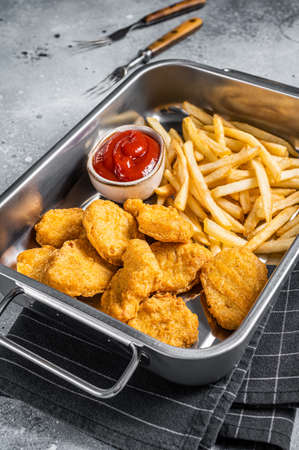 Fried crispy chicken nuggets with ketchup and French fries. Gray background. Top viewの写真素材