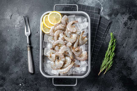 Raw pacific white shrimp prawn peeled with tail on ice. Black background. Top viewの写真素材