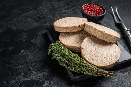 Uncooked Burgers cutlets made from plant based meat, raw vegan patties. Black background. Top view. Copy spaceの写真素材