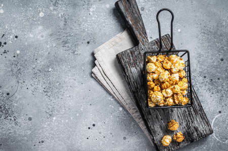 Popcorn with caramel in basket. Gray background. Top view. Copy space.の写真素材